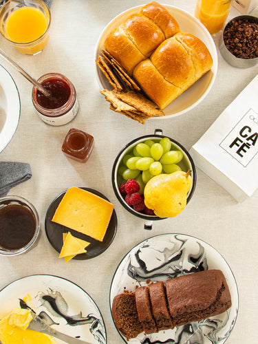 uma mesa coberta com cafe pratos de comida e bebidas